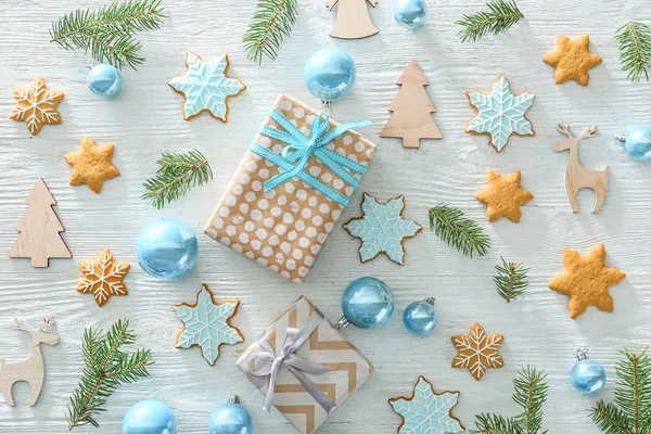 Vánoční výzdoba, dárkové krabice a sušenky na světlým dřevěném pozadí — Stock fotografie