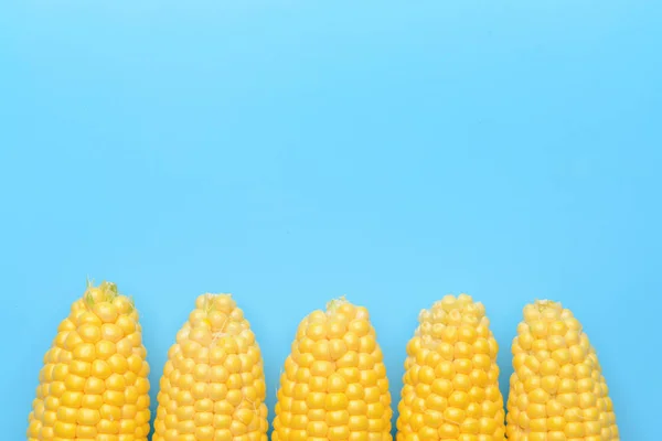 Свежие кукурузные початки на цветном фоне — стоковое фото
