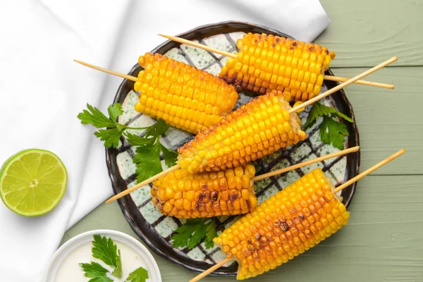 Тарелка с вкусными кукурузными початками на столе — стоковое фото
