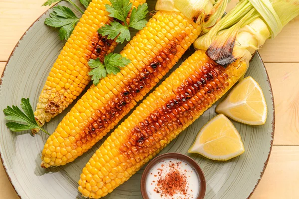 Sabrosas mazorcas de maíz a la parrilla en plato —  Fotos de Stock