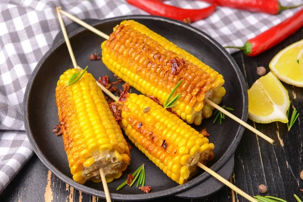 Placa con sabrosas mazorcas de maíz a la parrilla en la mesa —  Fotos de Stock