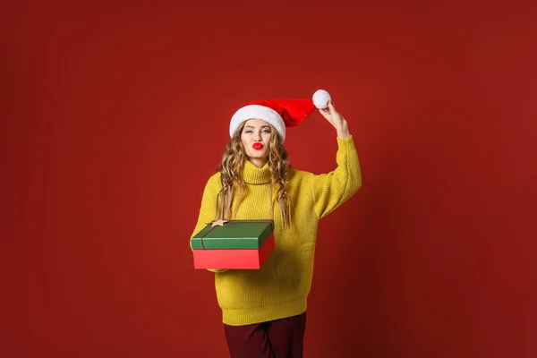 Belle jeune femme avec cadeau de Noël sur fond de couleur — Photo