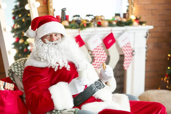 Papai Noel com leite e biscoito no quarto decorado para o Natal — Fotografia de Stock