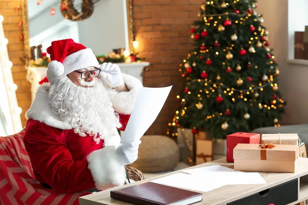 Jultomten läser önskelista i rum inredda för jul — Stockfoto