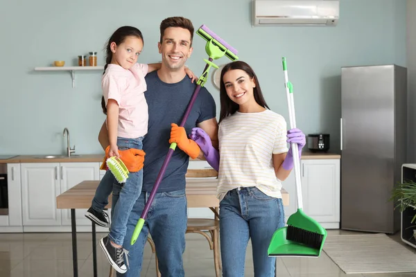 Portrait of family with cleaning supplies in kitchen — Stock Photo, Image
