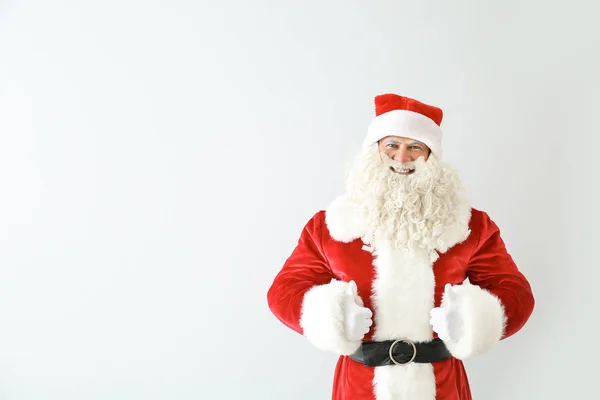 Retrato de Papai Noel mostrando polegar para cima no fundo de luz — Fotografia de Stock