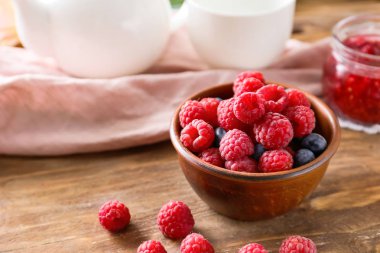 Ahşap masada lezzetli olgun çilek ile Bowl