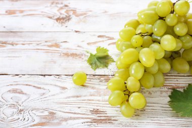 Beyaz ahşap arka planda lezzetli taze üzüm