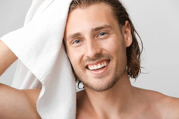 Όμορφος άνθρωπος σκουπίζει τα μαλλιά μετά το πλύσιμο σε γκρίζο φόντο — Φωτογραφία Αρχείου