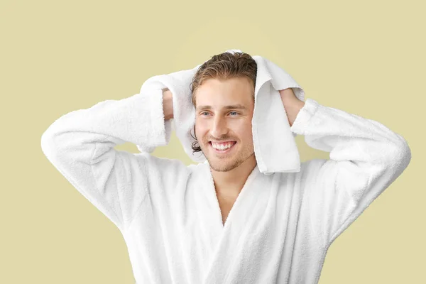 Homem bonito limpando o cabelo após a lavagem contra fundo de cor — Fotografia de Stock