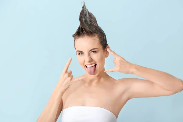 Cool young woman washing hair against color background — Stock Photo, Image