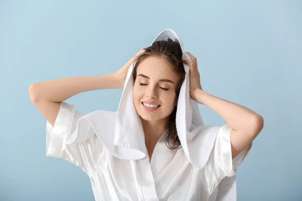 Bella giovane donna pulire i capelli dopo il lavaggio contro lo sfondo di colore — Foto Stock