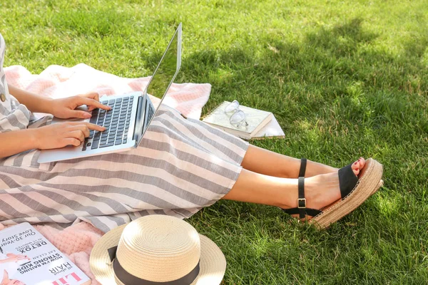 Blogger femenina con portátil sentado en la hierba en el parque —  Fotos de Stock