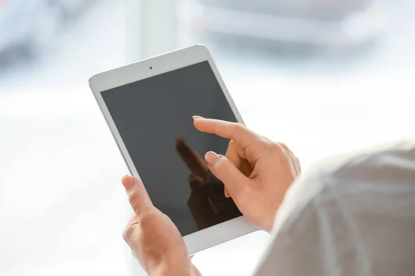Vrouw met behulp van Tablet PC in de buurt van venster — Stockfoto