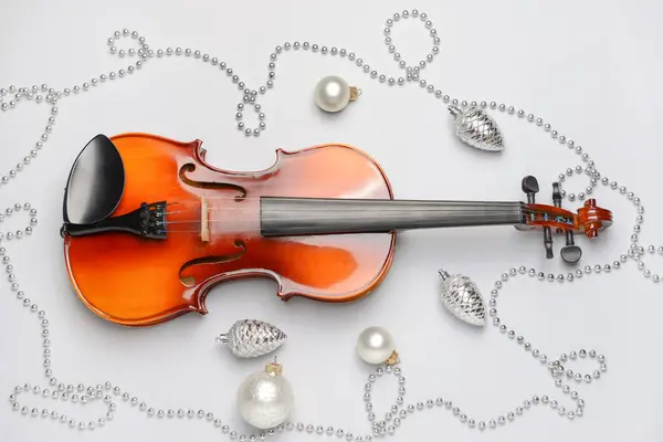 Violin och juldekor på ljus bakgrund — Stockfoto