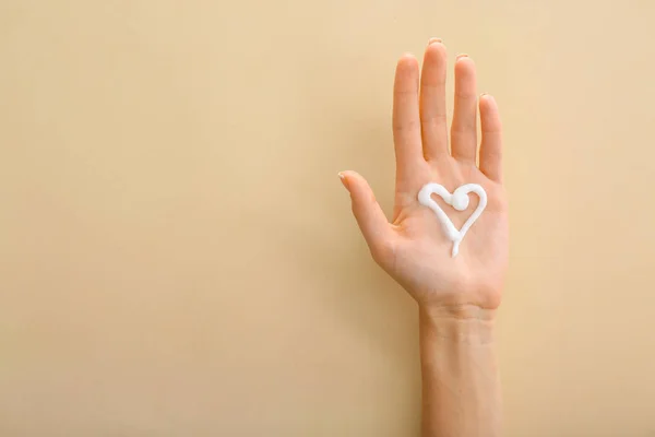 Mano femenina con crema natural sobre fondo de color — Foto de Stock