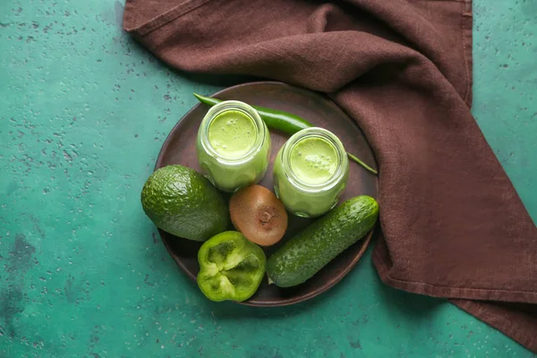 Jars of fresh healthy smoothie and ingredients on color background — Stock Photo, Image