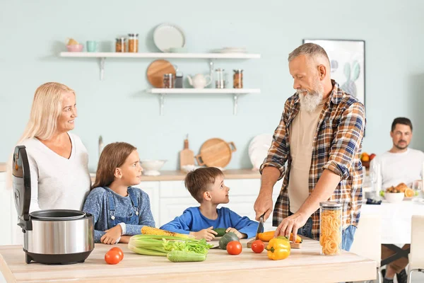 Grandparents and little children with modern multi cooker in kitchen — Stock Photo, Image
