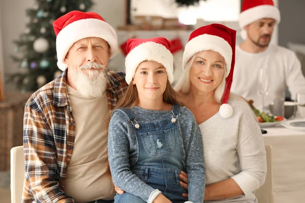Boldog nagyszülők kislánnyal során karácsonyi party otthon — Stock Fotó