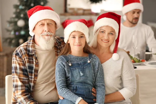 Abuelos felices con niña durante la fiesta de Navidad en casa — Foto de Stock