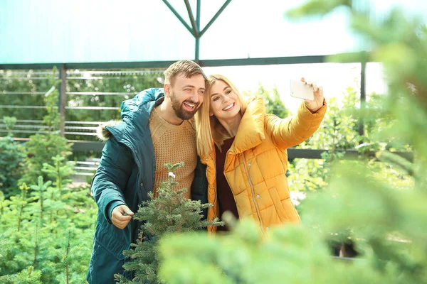 Couple taking selfie at Christmas tree market — Stock Photo, Image