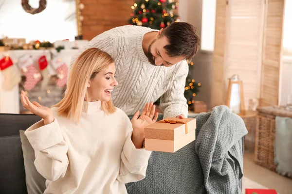 Szczęśliwy człowiek dający jego żona Boże Narodzenie obecny w Dom — Zdjęcie stockowe
