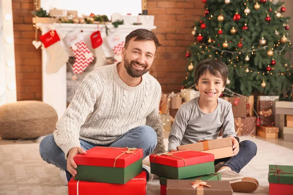 Homem feliz e seu filho com presentes de Natal em casa — Fotografia de Stock