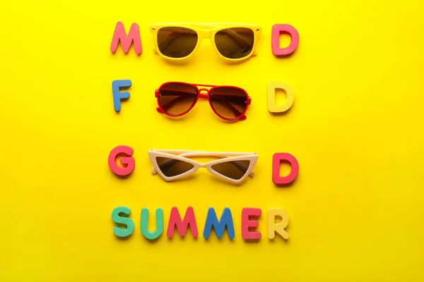 Composition avec des lunettes de soleil élégantes et des lettres sur fond de couleur — Photo
