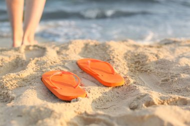 Tatil beldesinde kum plajda flip-flop