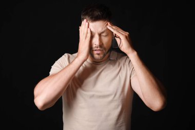 Karanlık arka planda stresli adam