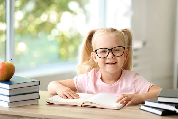 Χαριτωμένο μικρό μαθήτρια διαβάζει το βιβλίο στο γραφείο στην τάξη — Φωτογραφία Αρχείου