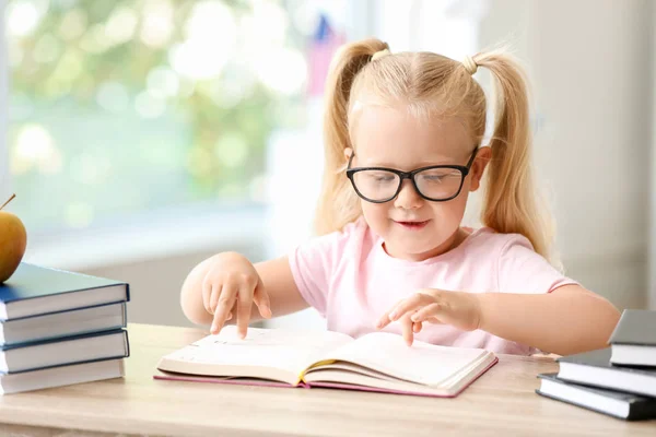 Carino piccolo libro di lettura studentessa alla scrivania in classe — Foto Stock