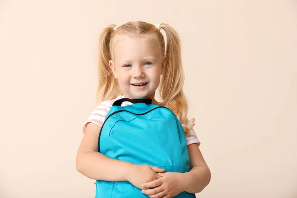 Cute little schoolgirl with backpack on light background — Stock Photo, Image