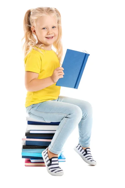 Carino bambina seduta su pila di libri sullo sfondo bianco — Foto Stock