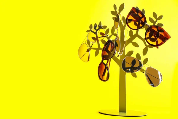 Тримач зі стильними сонцезахисними окулярами на кольоровому фоні — стокове фото
