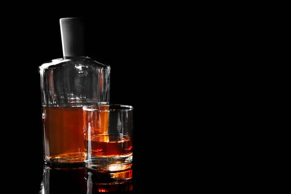 Bicchiere e bottiglia di whisky su sfondo scuro — Foto Stock