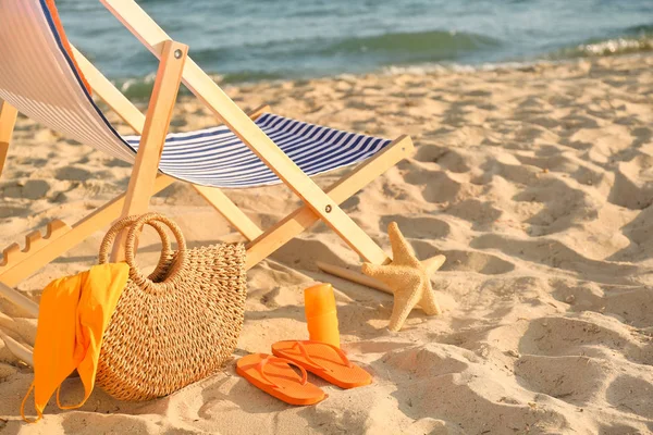 Silla con bolsa y accesorios en playa de arena — Foto de Stock