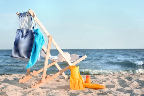 Stol med simfötter, väska och accessoarer på sandstrand — Stockfoto