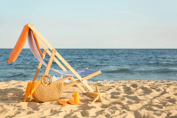 Chair with bag and accessories on sand beach — Stock Photo, Image