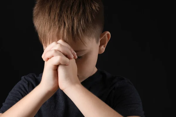Pregando bambino su sfondo scuro — Foto Stock