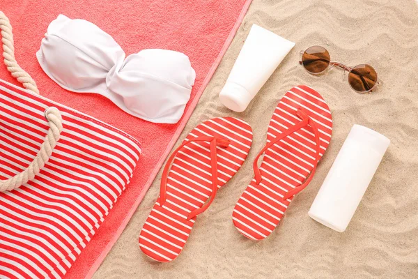 Female beach accessories with cosmetics on sand beach — Stock Photo, Image