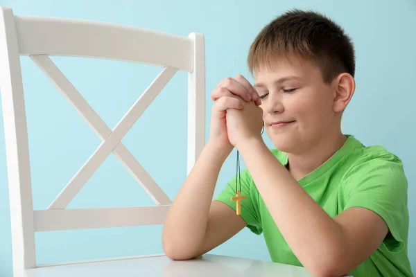 Praying little boy on color background — Stock Photo, Image