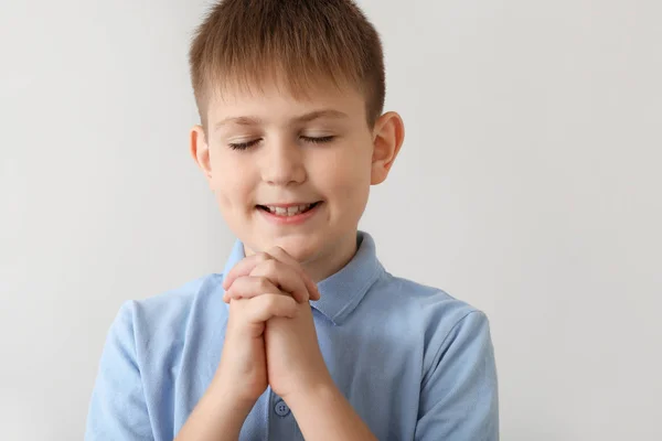 밝은 배경에 기도 하는 어린 소년 — 스톡 사진