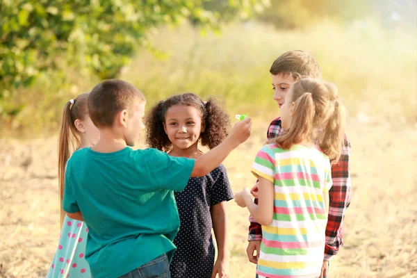 Niedliche kleine Kinder pusten Seifenblasen im Freien — Stockfoto