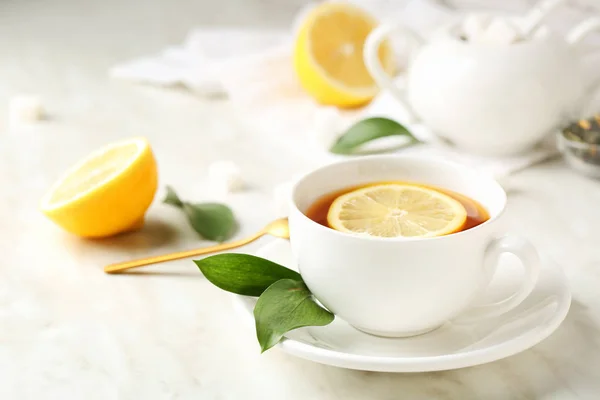 Taza de té caliente con limón en la mesa — Foto de Stock