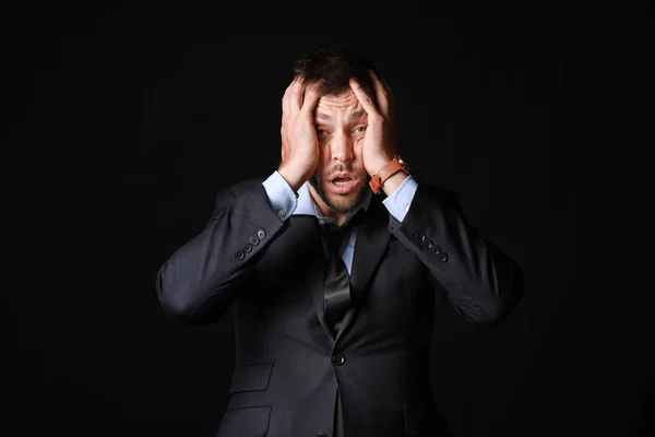 Stressed businessman on dark background — Stock Photo, Image