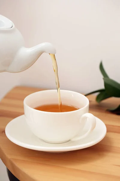 Verter el té caliente en taza sobre la mesa — Foto de Stock