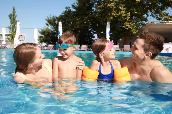 Família feliz na piscina no dia de verão — Fotografia de Stock