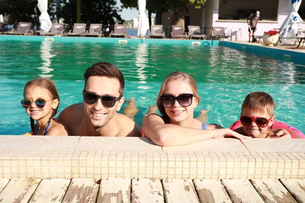 Familia feliz en la piscina en el día de verano — Foto de Stock