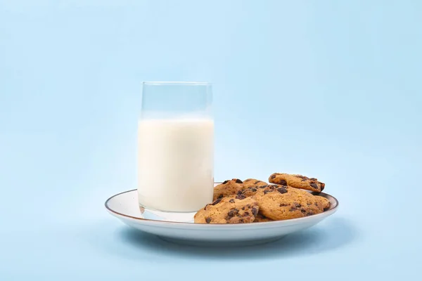 Plate with tasty cookies and glass of milk on color background — Stock Photo, Image